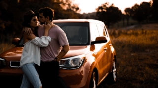 couple learning on brown SUV during s