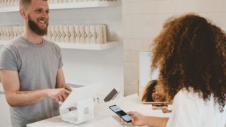 man in grey crew-neck t-shirt smiling to woman on counter