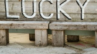 a wooden bench with the word lucky written on it