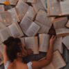 woman in white tank top reading book