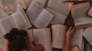 woman in white tank top reading book