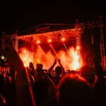 A crowd of people standing around a stage at night