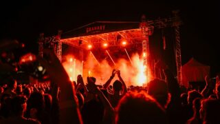 A crowd of people standing around a stage at night