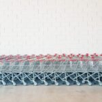 gray-and-red metal shopping cart lot beside wall