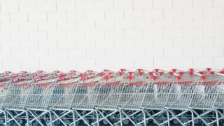 gray-and-red metal shopping cart lot beside wall